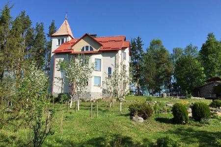 Двухэтажный замок в лесу рядом с озером в поселке Мельниково